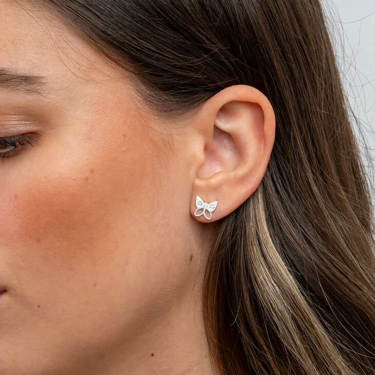 Model wearing delicate butterfly earrings with cubic zirconia detail