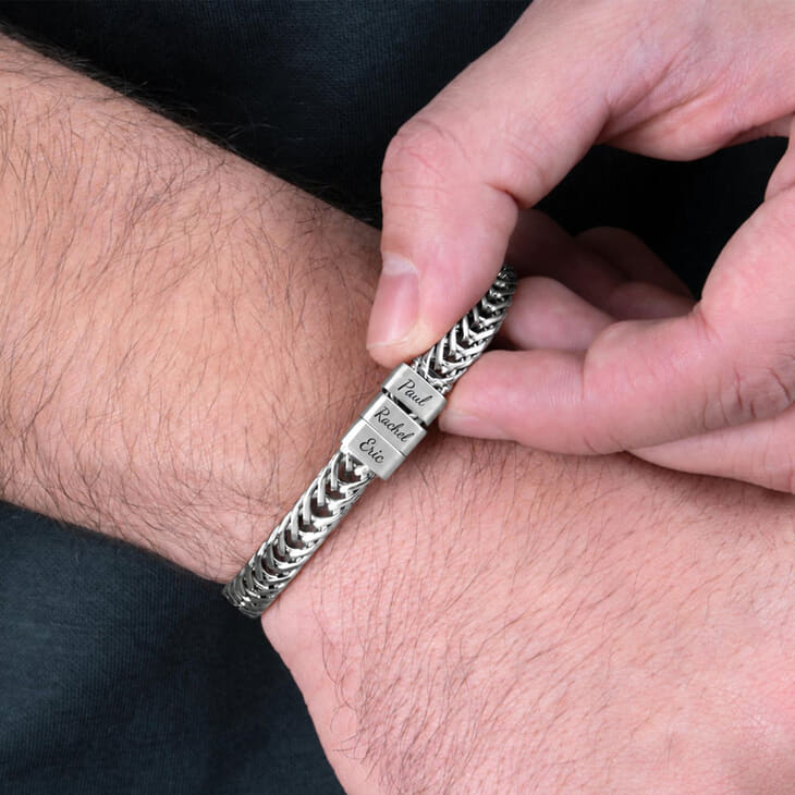 Stainless steel Dad bracelet worn on wrist with personalized name tags being adjusted