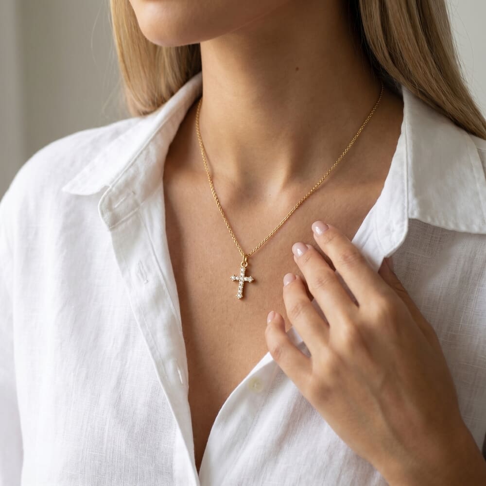 Stylish model highlights the Small Inlaid Cross necklace with a classic white top
