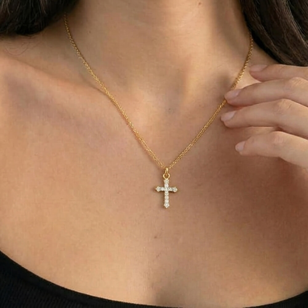 Stylish model wears the Small Inlaid Cross necklace over a classic black top