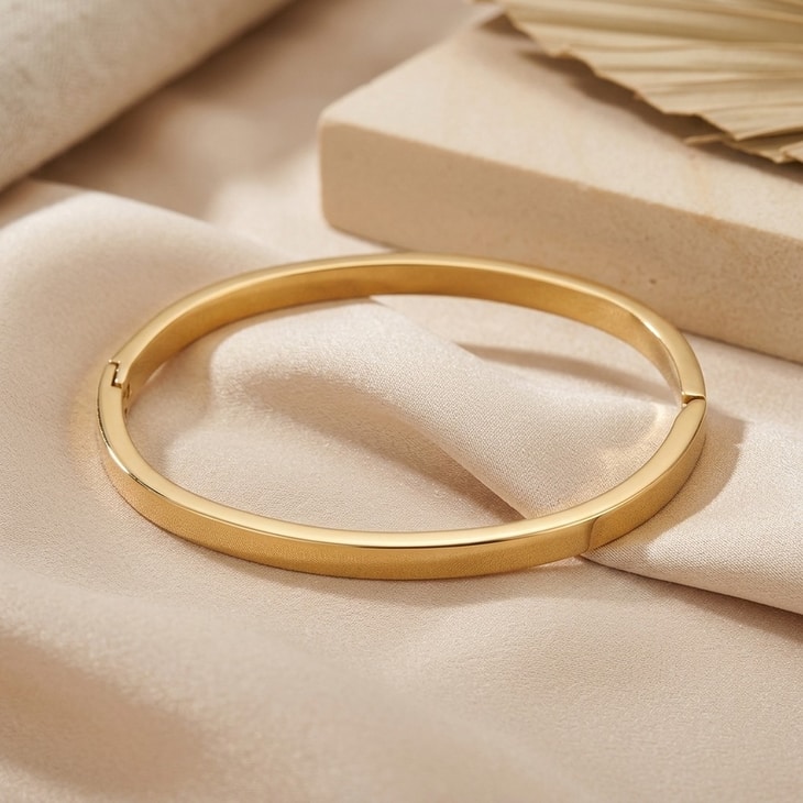 Thin Rounded Edge Bangle Bracelet showcased on delicate fabric