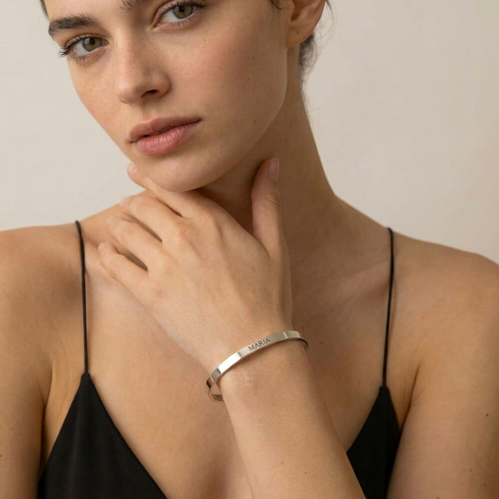 Woman showcasing a personalized thin open bangle bracelet with custom engraving on her wrist