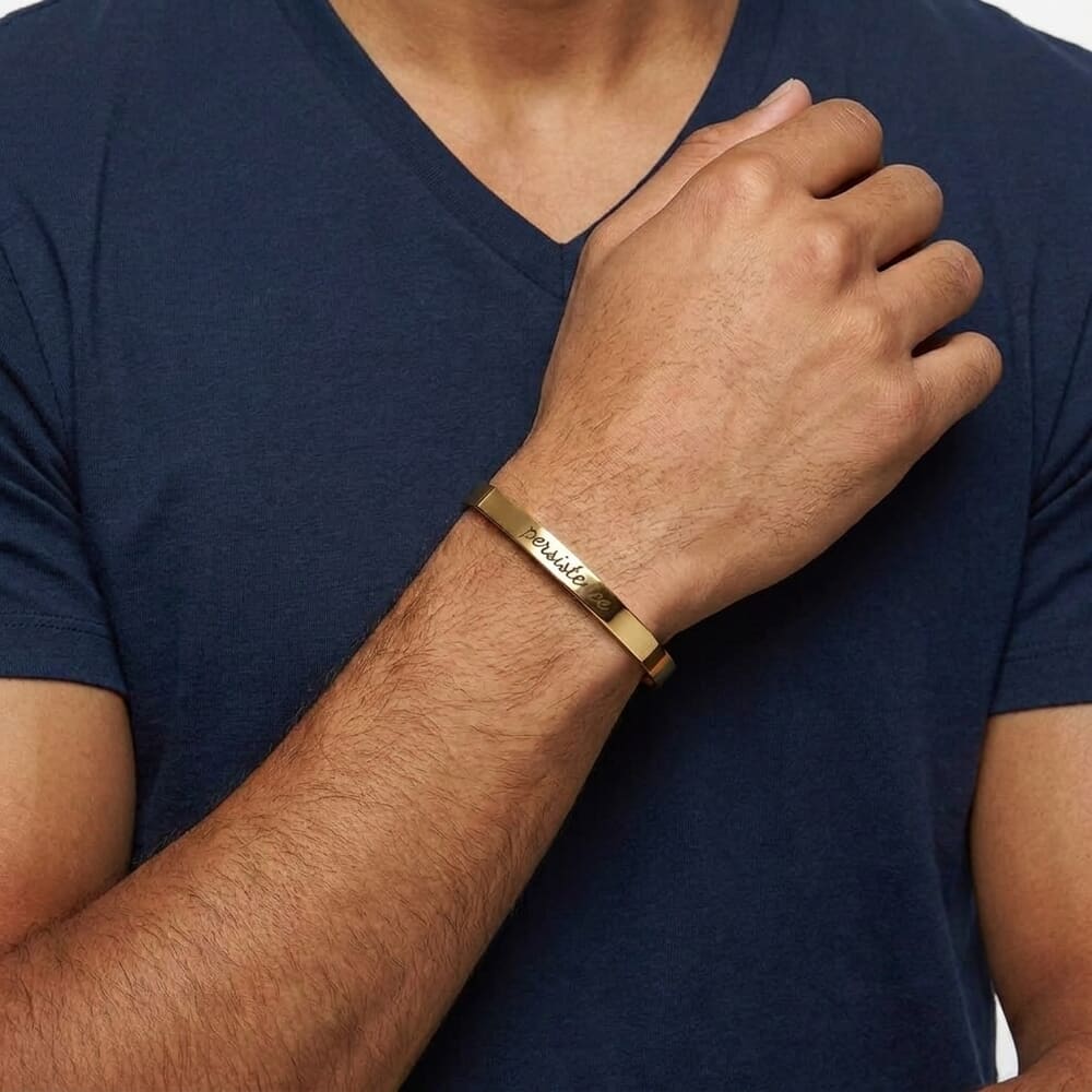 Person styling a personalized engraved cuff bracelet on their wrist