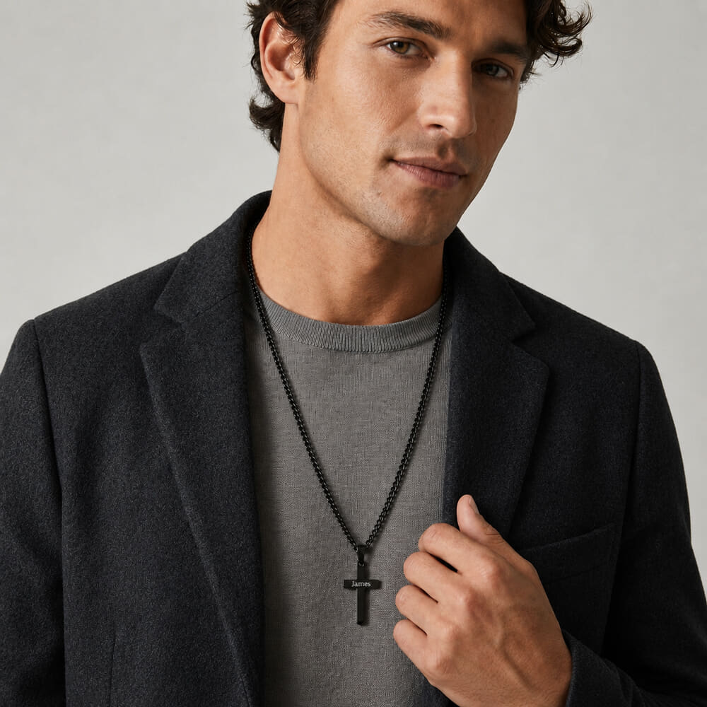 Man accessorized with an engraved black cross necklace, exemplifying modern elegance