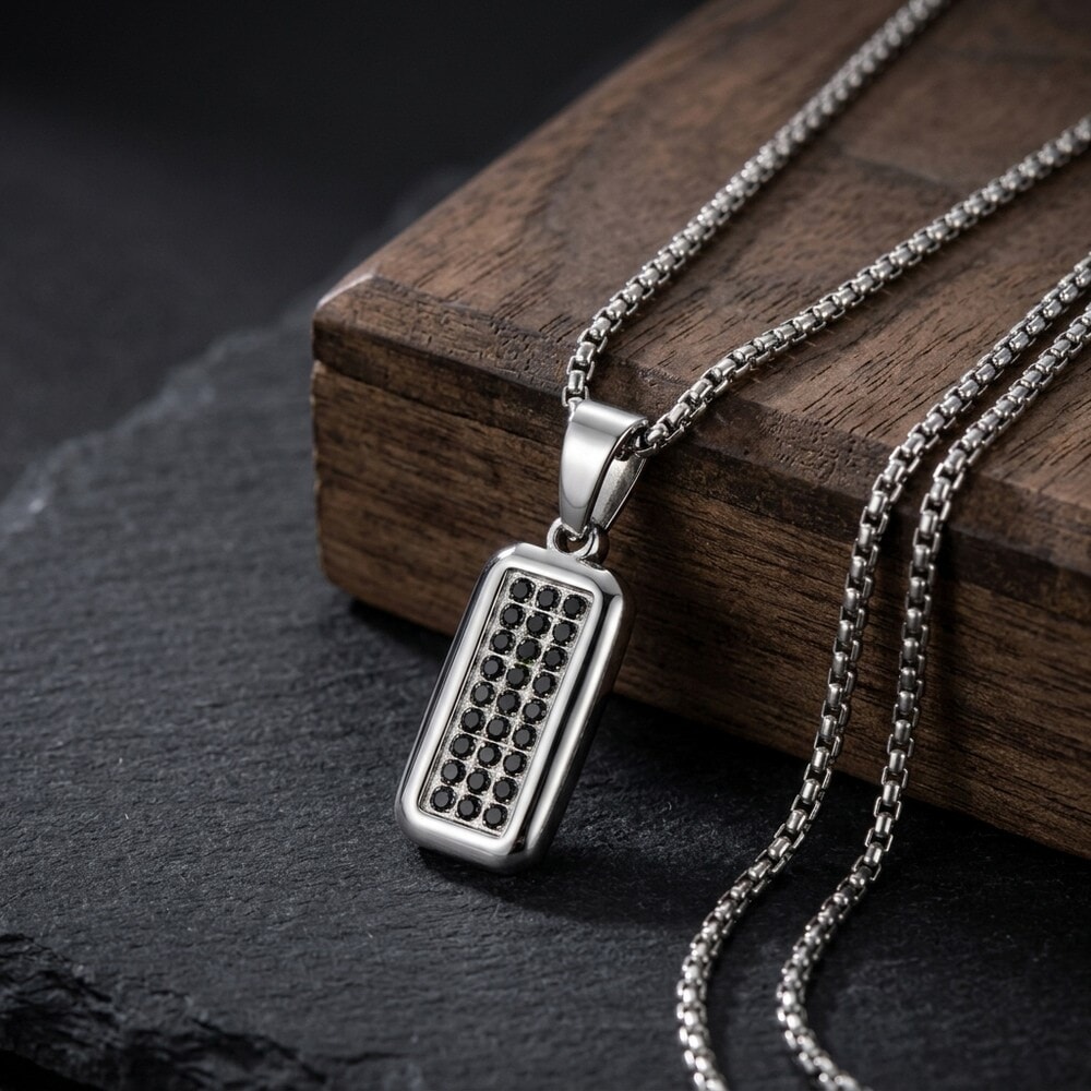 Model wearing Men's Black Zircon Tag Necklace, emphasizing the sleek pendant set against natural wood