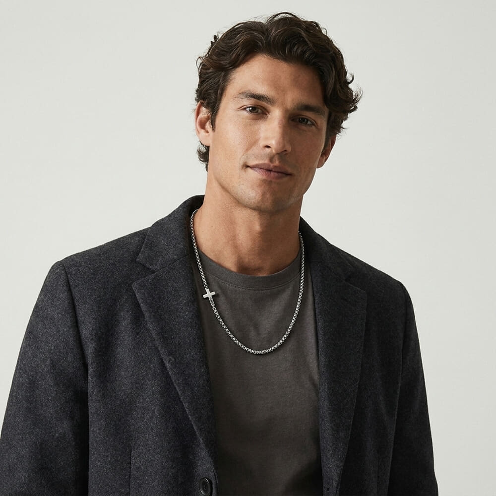 Man displaying Personalized Men's Sideways Cross Necklace in a sophisticated ensemble