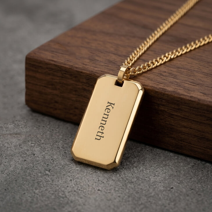 Men's custom gold dog tag necklace displayed on wood background
