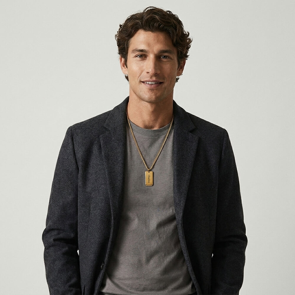 Man displaying custom engraved dog tag necklace with relaxed elegance