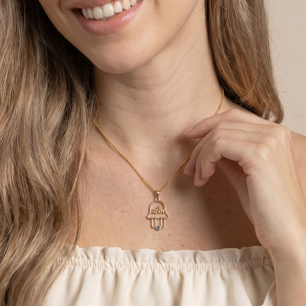 Close-up of model wearing a personalized Hamsa necklace with a unique birthstone