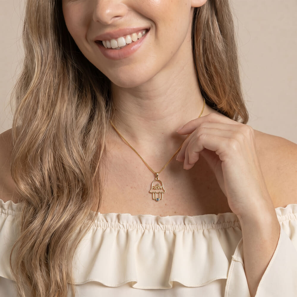 Close-up of model wearing a personalized Hamsa necklace with a subtle design