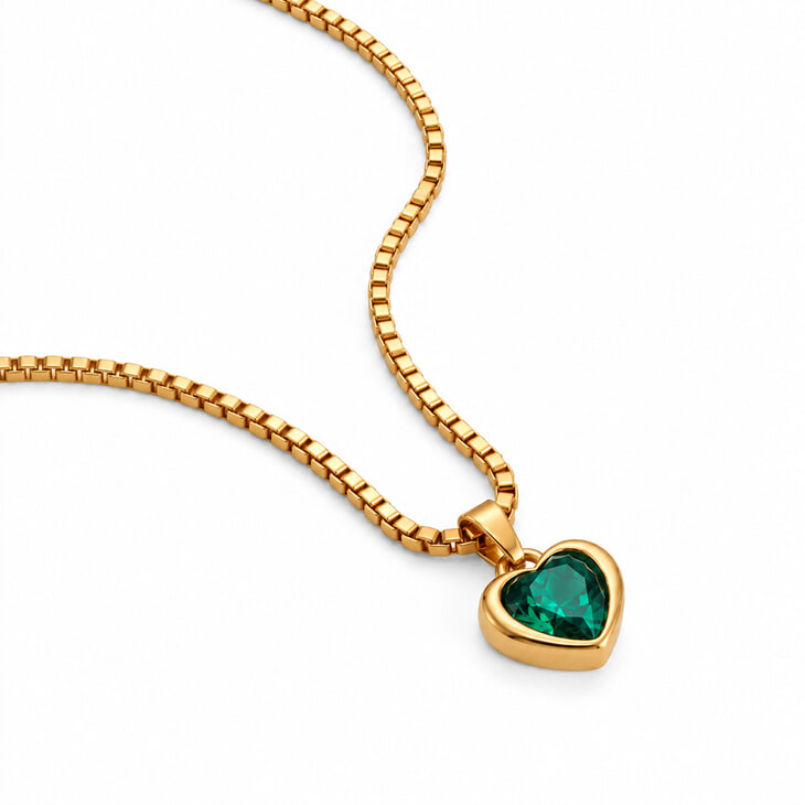 Gold heart pendant necklace accented by a beautiful green gem