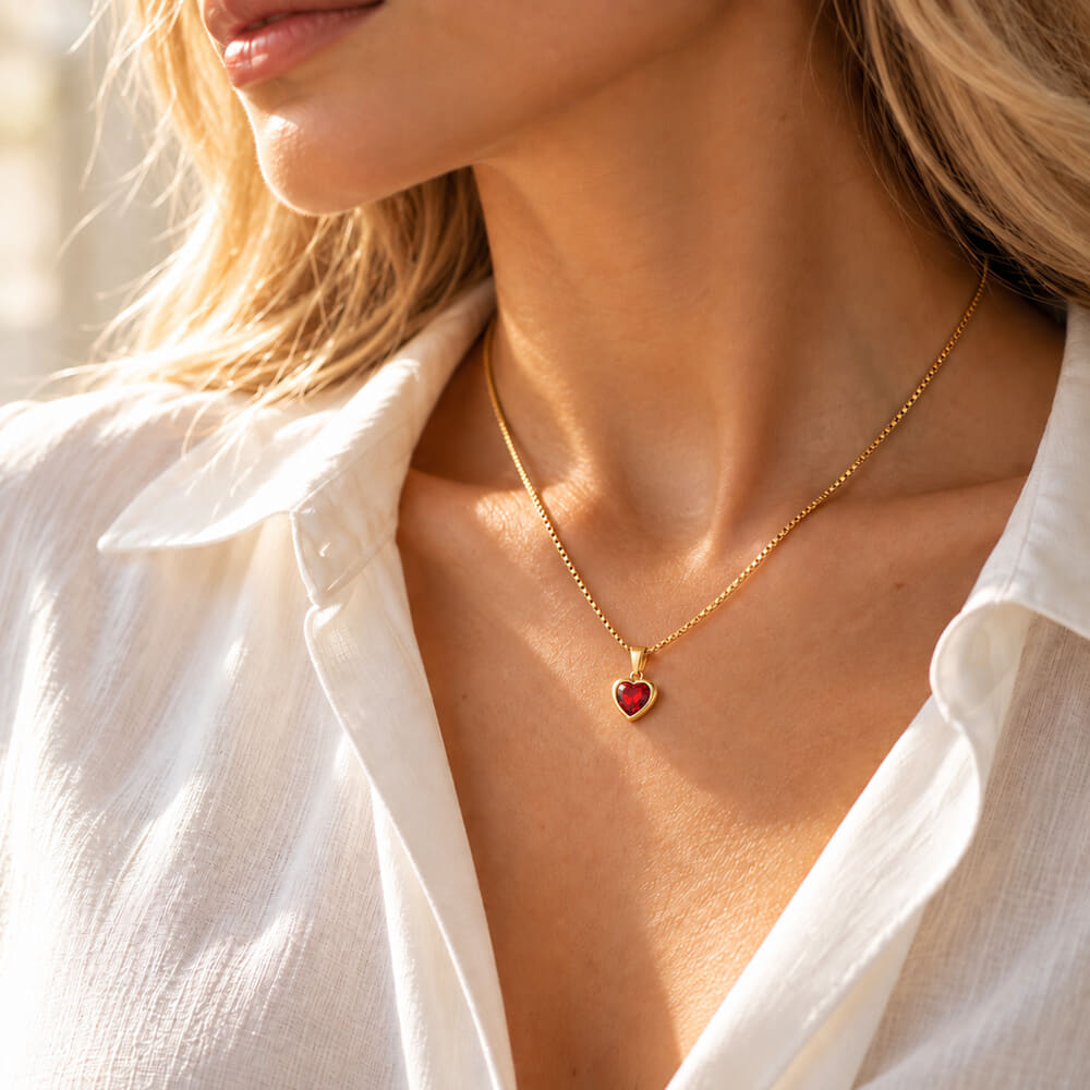 Woman elegantly styled with a heart-shaped gemstone necklace in natural light